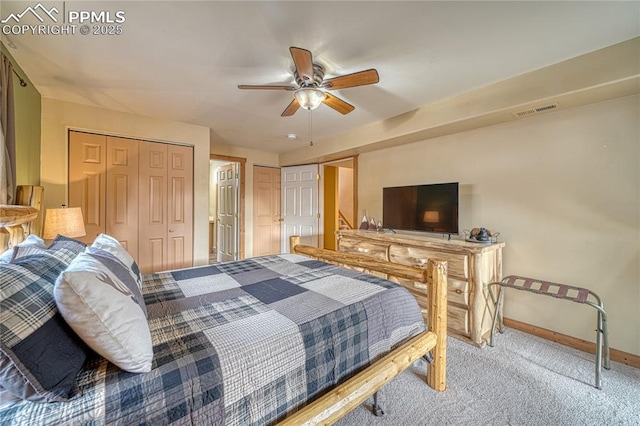 bedroom featuring carpet floors, multiple closets, visible vents, ceiling fan, and baseboards