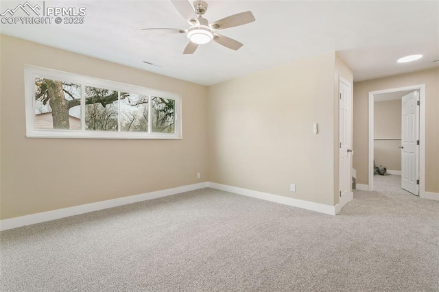 carpeted spare room featuring ceiling fan