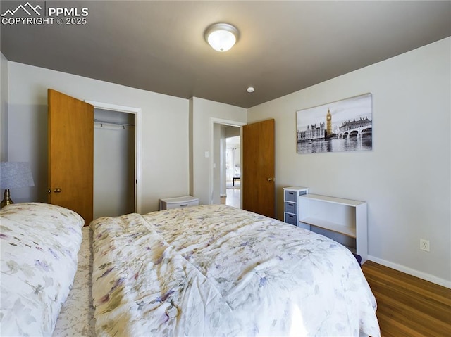 bedroom with dark hardwood / wood-style floors and a closet