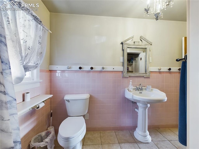 bathroom featuring tile walls, tile patterned floors, and toilet