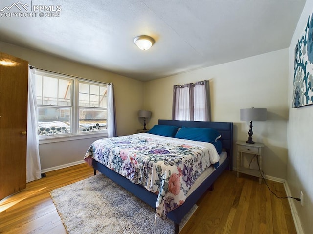 bedroom featuring hardwood / wood-style flooring and multiple windows