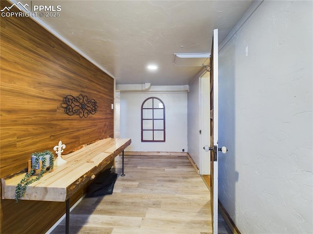 hall featuring light hardwood / wood-style flooring and wood walls