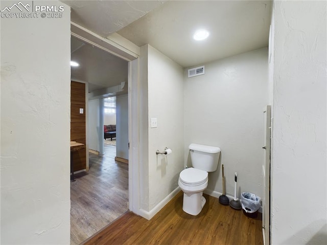 bathroom featuring hardwood / wood-style flooring and toilet