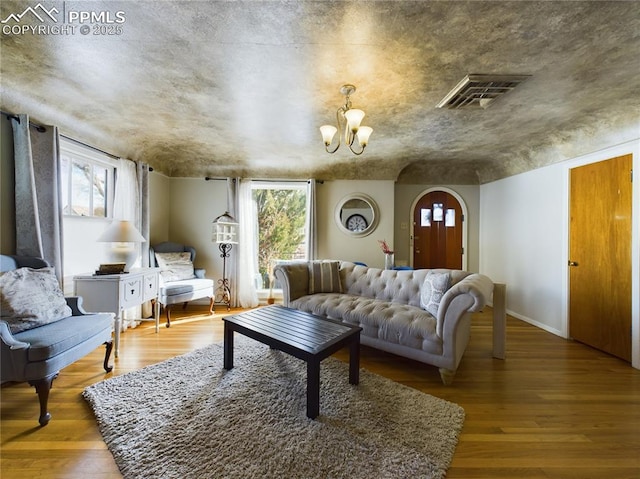 living room with a chandelier and light wood-type flooring