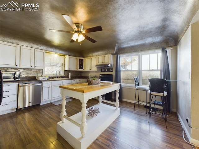 kitchen featuring sink, appliances with stainless steel finishes, dark hardwood / wood-style flooring, ceiling fan, and decorative backsplash