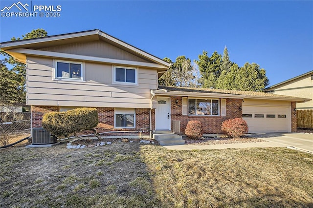 split level home with a garage, a front yard, and central AC unit