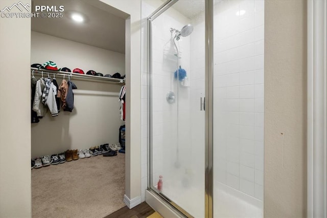 full bathroom with a stall shower and a walk in closet