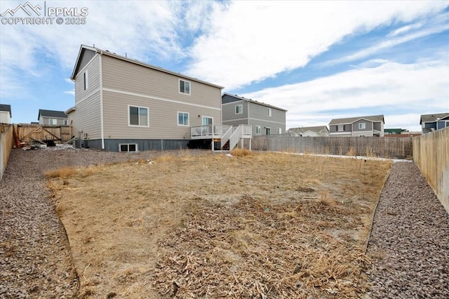 rear view of house with a fenced backyard