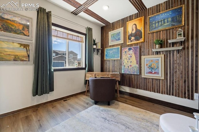 living area with baseboards and wood finished floors