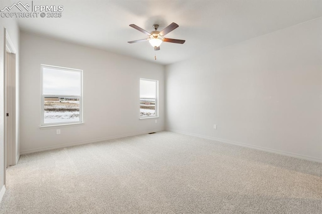 empty room featuring ceiling fan and light colored carpet