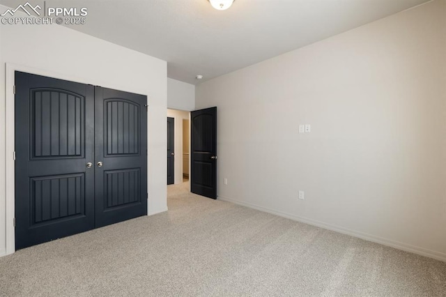 unfurnished bedroom featuring light carpet and a closet