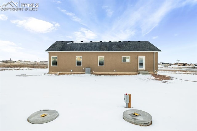 snow covered house with central AC