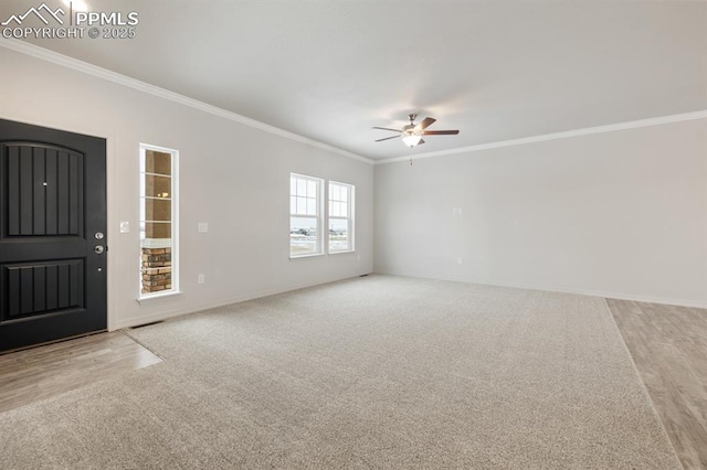 unfurnished living room featuring crown molding, ceiling fan, and light carpet