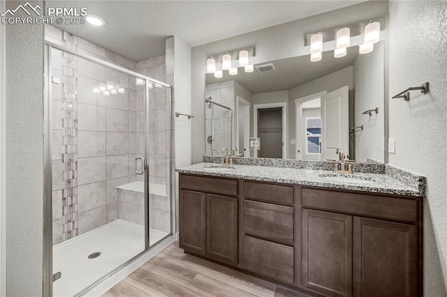 bathroom featuring vanity, hardwood / wood-style floors, and an enclosed shower