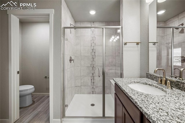 bathroom featuring hardwood / wood-style flooring, vanity, toilet, and an enclosed shower