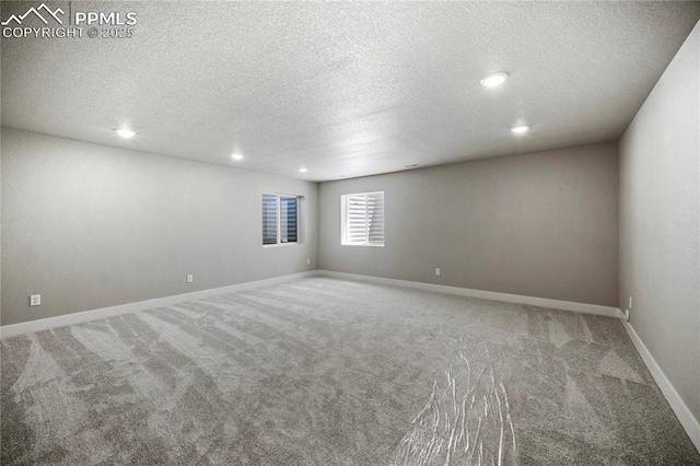 carpeted empty room with a textured ceiling