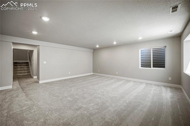 carpeted spare room with a textured ceiling