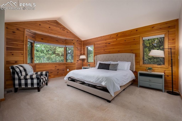 bedroom featuring lofted ceiling, multiple windows, light colored carpet, and wood walls