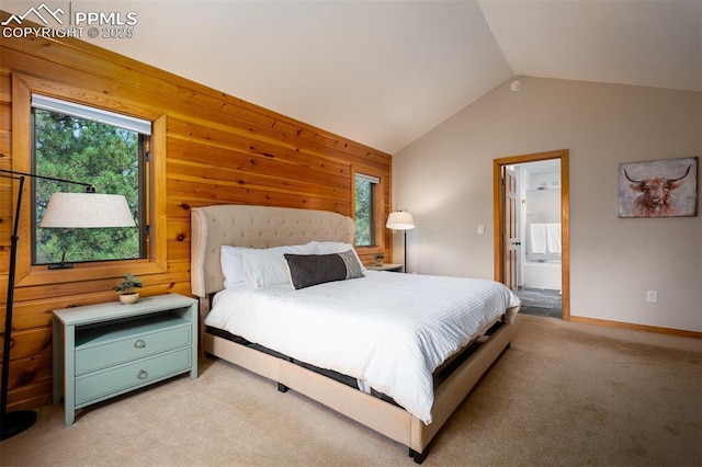 bedroom featuring multiple windows, light colored carpet, ensuite bathroom, and lofted ceiling