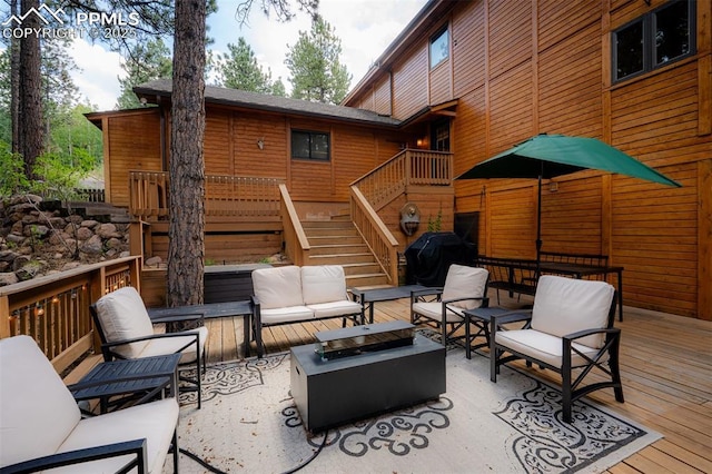 deck with grilling area and an outdoor living space with a fire pit