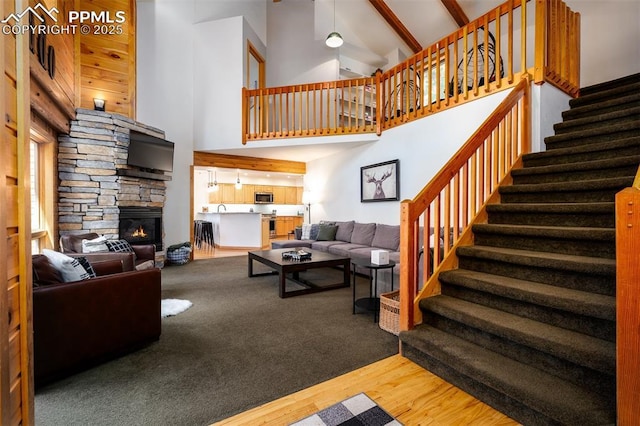 living room with a fireplace, high vaulted ceiling, and hardwood / wood-style floors