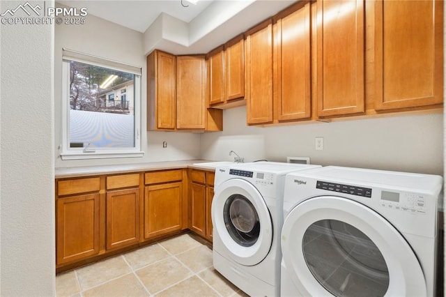 clothes washing area with light tile patterned flooring, cabinets, sink, and washer and dryer