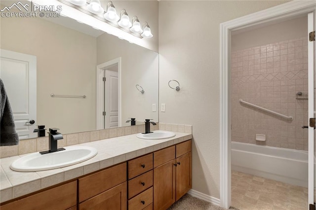 bathroom with tiled shower / bath and vanity