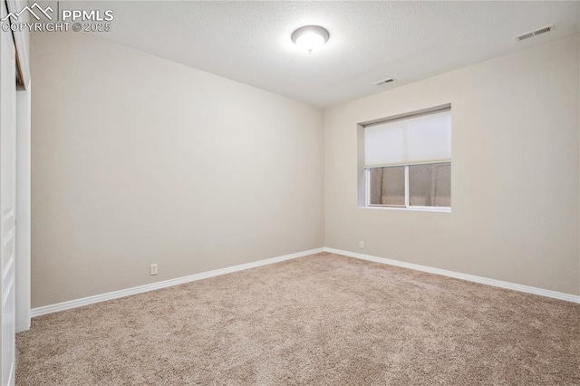 carpeted spare room with a textured ceiling