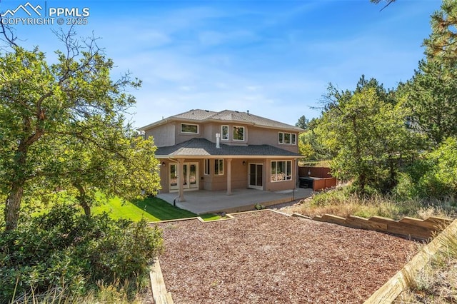 back of house featuring a patio area and a hot tub