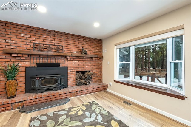 unfurnished living room with hardwood / wood-style floors and a wood stove