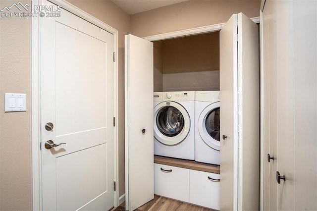 clothes washing area featuring independent washer and dryer and light hardwood / wood-style flooring