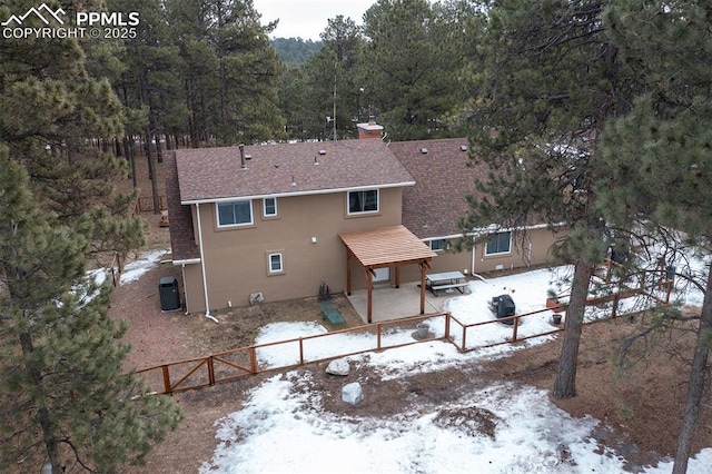 snow covered property with central AC and a patio area