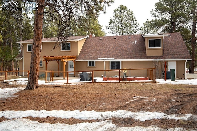 snow covered rear of property featuring a pergola and central air condition unit