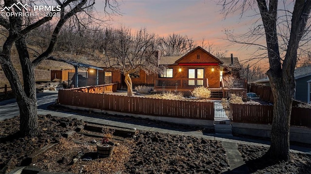 back of house at dusk featuring a fenced front yard