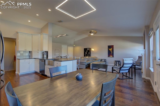 dining space featuring lofted ceiling, dark hardwood / wood-style floors, and sink