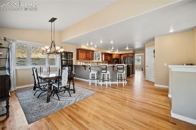 dining space with light wood-type flooring and a chandelier