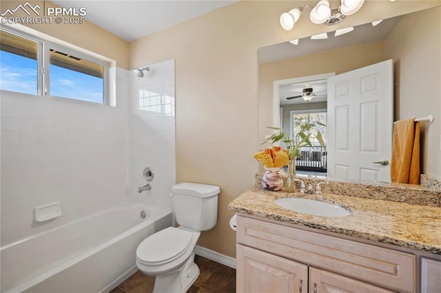 full bathroom featuring tiled shower / bath combo, vanity, and toilet