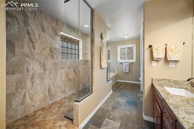 bathroom with vanity, tiled shower, and toilet