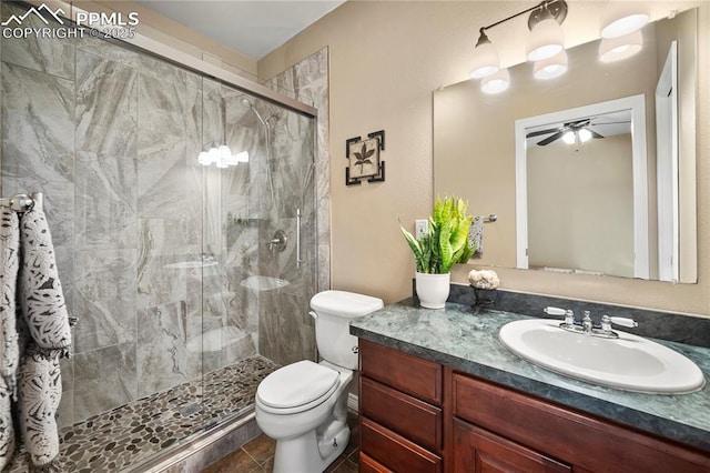 bathroom featuring vanity, ceiling fan, a shower with door, and toilet