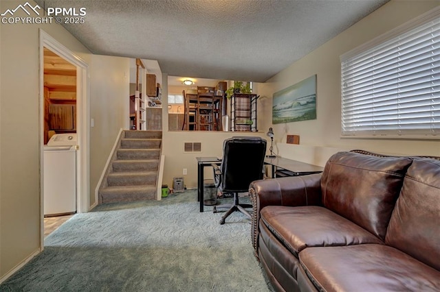 carpeted office featuring washer / dryer and a textured ceiling