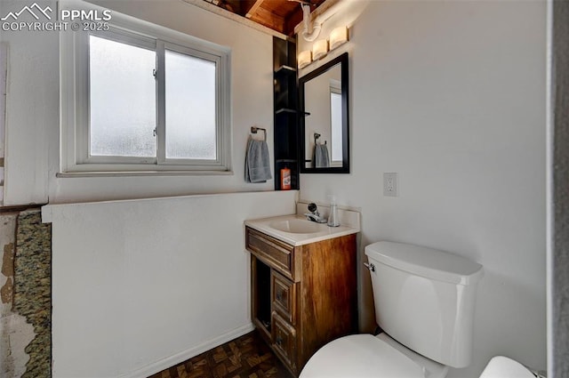 bathroom featuring vanity, parquet flooring, and toilet