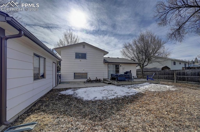 rear view of house with a wooden deck and a patio area