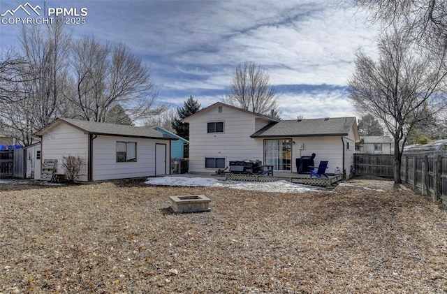 back of property with a fire pit and a patio area