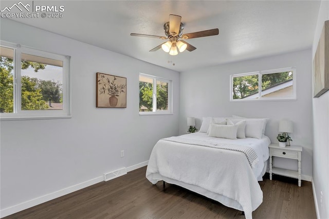 bedroom with dark hardwood / wood-style floors and ceiling fan