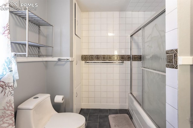 bathroom with combined bath / shower with glass door, tile patterned floors, and toilet