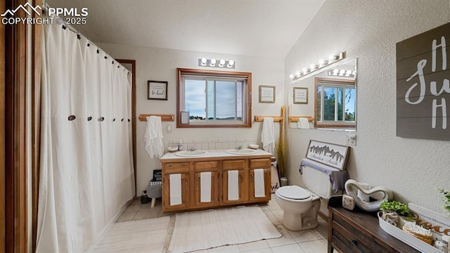 bathroom with vanity, lofted ceiling, tile patterned floors, and toilet