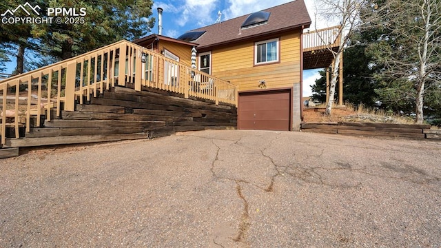 view of front of property featuring a garage and a wooden deck