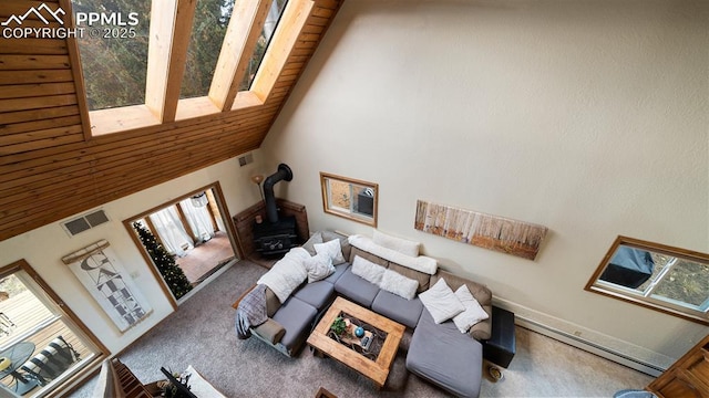 carpeted living room with wood ceiling, high vaulted ceiling, and a wood stove