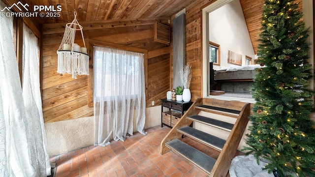 stairway with wood ceiling and wooden walls