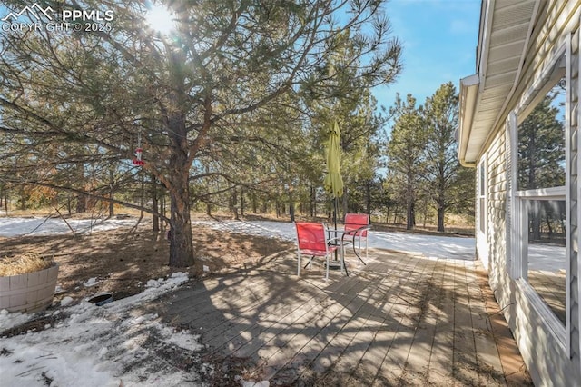 snow covered patio featuring a wooden deck